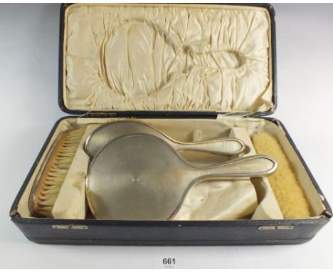 A silver dressing table set with mirror and three brushes, Birmingham 1925, case a/f 