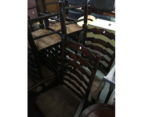 A set of six 20th century oak ladder back chairs, with rush seats (two carvers) 