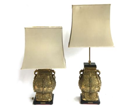 A pair of substantial Chinese brass double dragon table lamps, of square baluster form, with dragon head lugs and loop handle