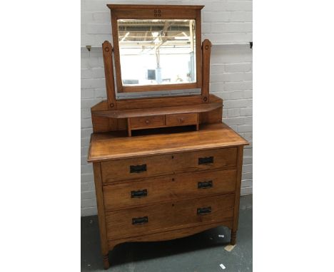 A 20th century light oak dressing table/chest of drawers, bevelled mirror with two small drawers below, over three graduating