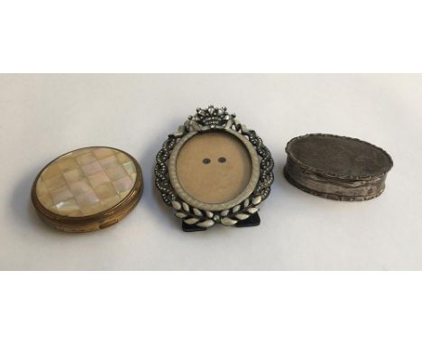 A small silver dressing table pot; enamel and glass set oval picture frame; and a compact (3) 