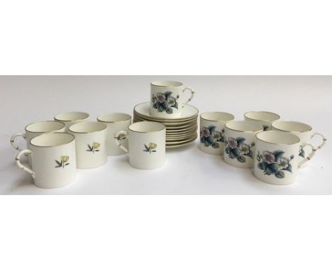 A Royal Worcester set of 12 coffee cans and 11 saucers, decorated with floral images and heightened in gilt 