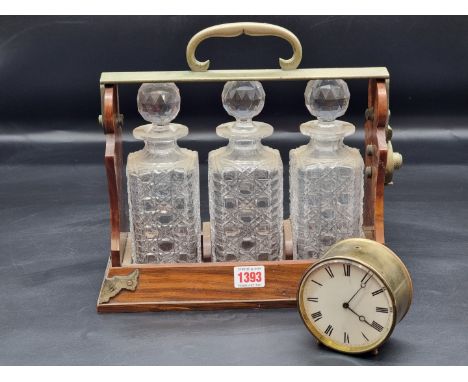A walnut and electroplate three bottle tantalus, by Betjemann, 31cm wide, (chips to collars of two decanters); together with 