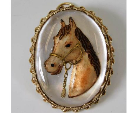 A 9ct vintage gold pendant with enamel painting of horse in reverse on mother of pearl 22.8g