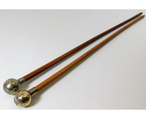 A silver topped malacca cane swagger stick twinned with one white metal bearing military crest
