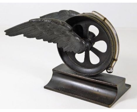 A desk thermometer mounted on bronze winged wheel &amp; plinth 3.75in tall