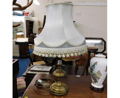 A decorative brass lamp with shade