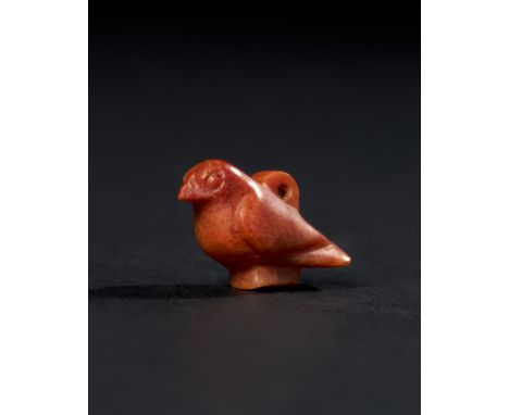 This finely crafted Ancient Egyptian bird-shaped amulet is made from reddish-orange agate, dating back to the New Kingdom per