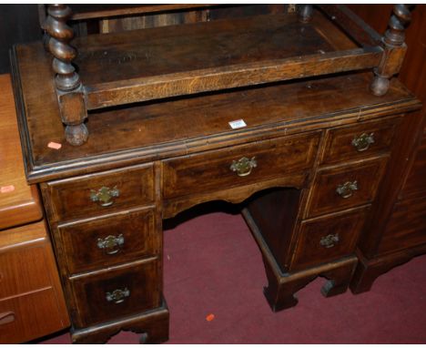 An early Georgian style figured walnut, feather-banded and further crossbanded kneehole writing desk, having an arrangement o