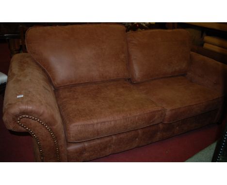 A contemporary tan suede upholstered three seater sofa, w.220cm