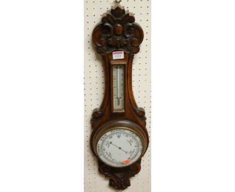 A 1930s carved oak two dial aneroid wheel barometer