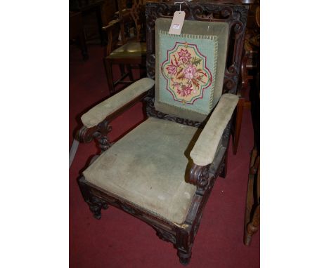 A Victorian carved oak framed and floral needlework tapestry upholstered open armchair 