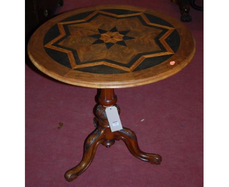 A Victorian walnut and specimen wood inlaid tilt-top pedestal tripod table, raised on leaf carved hip supports, dia.75cm