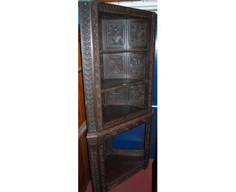 A late 19th century panelled and low relief carved oak freestanding open corner shelf having platform undertier, height 182cm