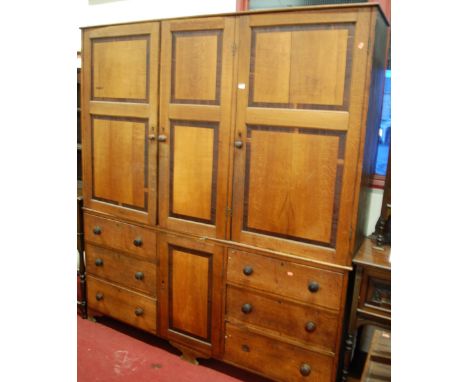 A large Victorian country house oak and mahogany cross banded estate cabinet, having three recessed panelled upper doors over