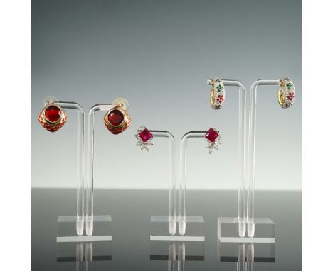 A trio of distinctive earring pairs, each showcasing unique design elements. The first pair features bold, square-cut red fac