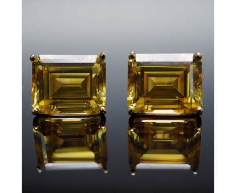 Elegant pair of stud earrings featuring radiant emerald cut citrine stones, each securely set in classic four-prong 14K yello