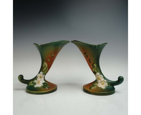 Matched pair of cornucopia-form vases from Roseville Pottery in the White Rose pattern, showcasing raised white blossoms and 