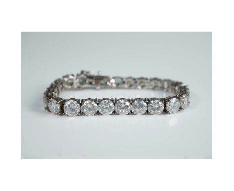 Sterling silver tennis bracelet set with a continuous row of round-cut clear stones in four-prong settings. Marked 925 on the