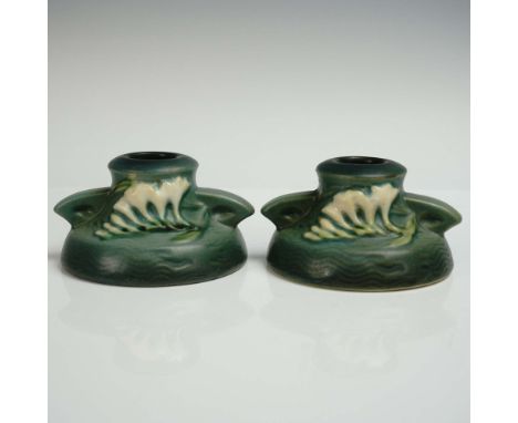 A pair of alluring pottery candlestick holders featuring sculpted freesia blossoms in creamy white with green foliage set aga