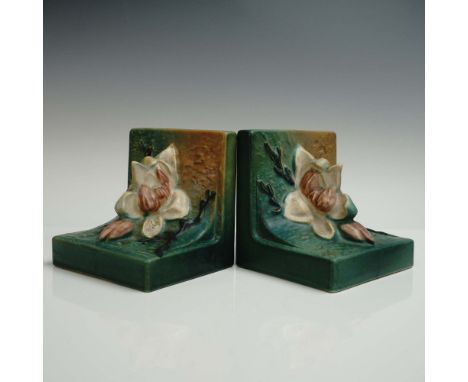 Pair of pottery bookends, each featuring a sculpted creamy white magnolia blossoms with deep pink accents and raised branch d