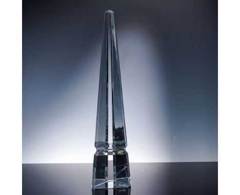 This elegant Baccarat crystal obelisk sculpture features a sleek, geometric form with clean, faceted lines tapering to a fine