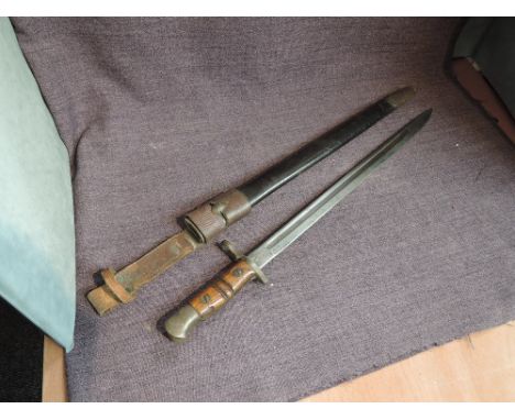 A WW1 British Bayonet pattern 1913, marked Remmington on blade, numbered 126, military marking seen with leather scabbard and