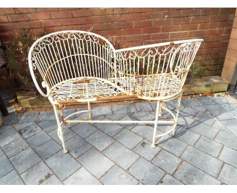 Garden furniture - a white painted metal love seat / kissing seat, 77 cm (h) c 104 cm (w) x 54 cm (d)