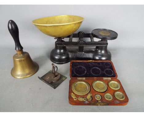 A set of kitchen scales, wood cased set of Avery weights and a small hand bell.