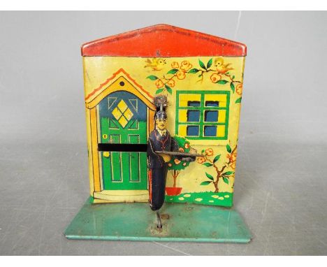 A novelty tinplate, Burnett Postman, money bank by Chad Valley in the form of a cottage with postman who deposits coin in let