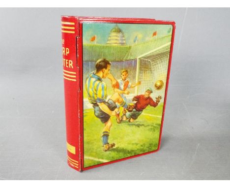 A Chad Valley novelty tinplate money box in the form of a book, titled 'The Sharp Shooter' and printed with Wembley football 