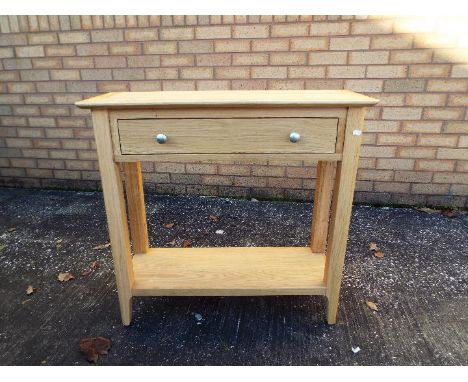A modern, light oak console table, approximately 75 cm x 79 cm x 30 cm.