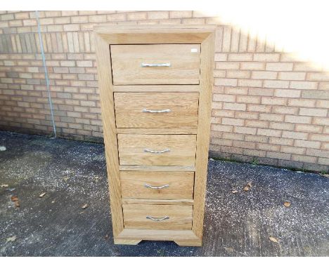 A modern, light oak, tall boy chest of five drawers by J. B. Global, approximately 120 cm x 52 cm x 42 cm.