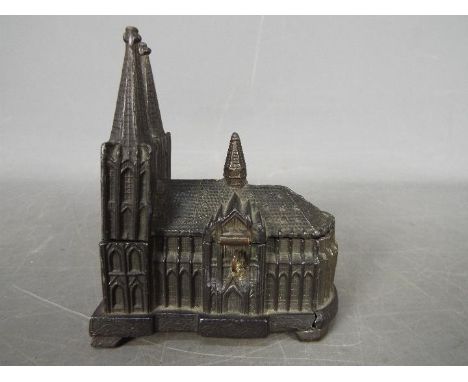 A vintage, cast metal, money bank of small scale depicting Cologne Cathedral, approximately 9.5 cm (h)