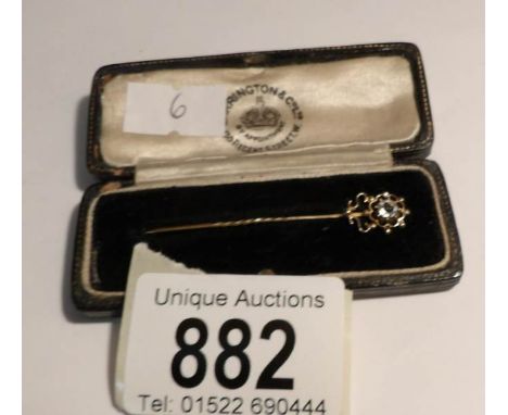 A superb cased gold stick pin set with a solo white stone