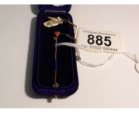 A cased gold stick pin with an hand brooch safety chain, pin set coral