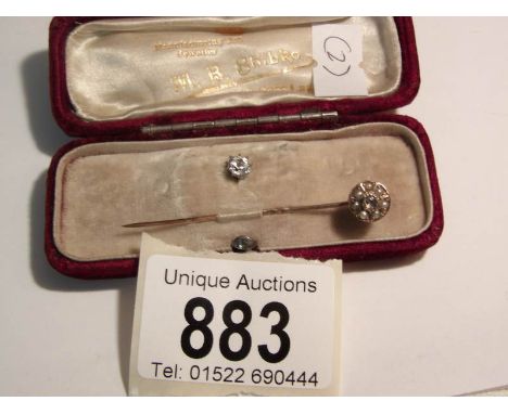 A cased gold stick pin set diamond and seed pearls together with a solo diamond (for changing the head)