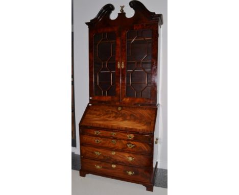 A George III mahogany and cross banded bureau bookcase, 3rd quarter 18th century, the moulded swan neck pediment above astrag