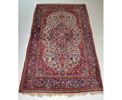 Kashan rug, Central Iran, the cream field of scrolling vines around an indigo medallion framed by spandrels and meandering vi