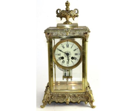 A gilt metal four glass striking mantel clock, circa 1900, urn finial and scroll borders, enamel dial with Roman numerals, tw