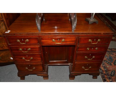 A George II mahogany knee hole desk, late 18th century, with central frieze drawer flanked by eight graduated drawers all aro