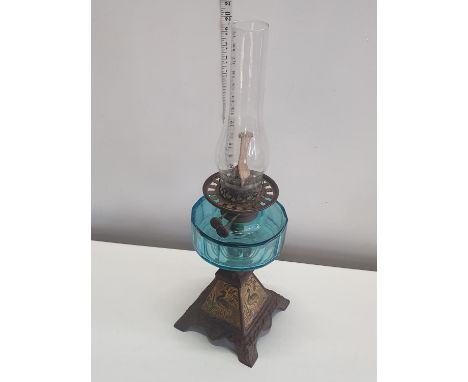 A antique cast base oil lamp with blue glass reservoir H54cm, shipping unavailable