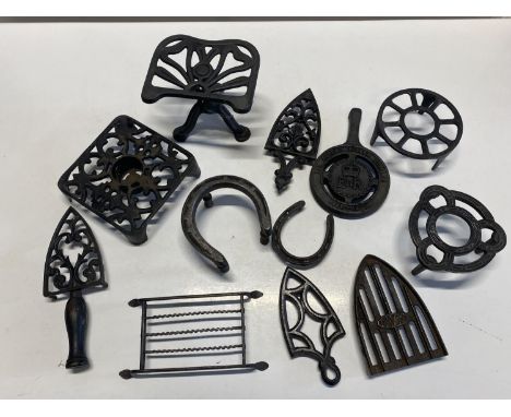 A job lot of assorted antique and vintage trivets, shipping unavailable