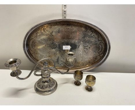 A silver plated galleried tray with candlestick and two egg cups
