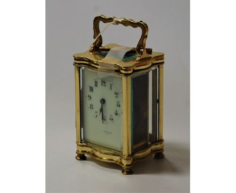 An early 20th century lacquered brass carriage clock, having visible platform escapement, indistinctly signed white enamel di