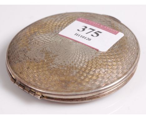 A lady's silver powder compact, having engine turned decoration, 7cm