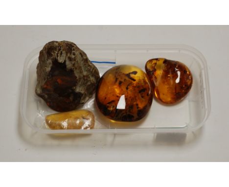 A large amber coloured resin boulder, with various inclusions, w.9cm; together with three other resin specimens (4)