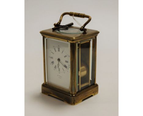 An early 20th century lacquered brass cased carriage clock, having an enamelled dial with Roman numerals and Arabic outer num