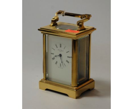 A reproduction lacquered brass carriage clock, retailed by W.E. Clark of Lewes, h.13cm (handle down)