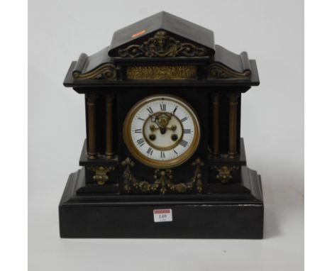A Victorian slate mantel clock with brass detailing and visible escapement, height 37cm.Glass intact.Several cracks to the en